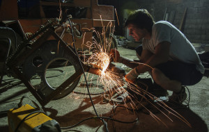 Baletic, 22, performs last minute work on scrap metal parts for his sculpture at junkyard in Podgorica